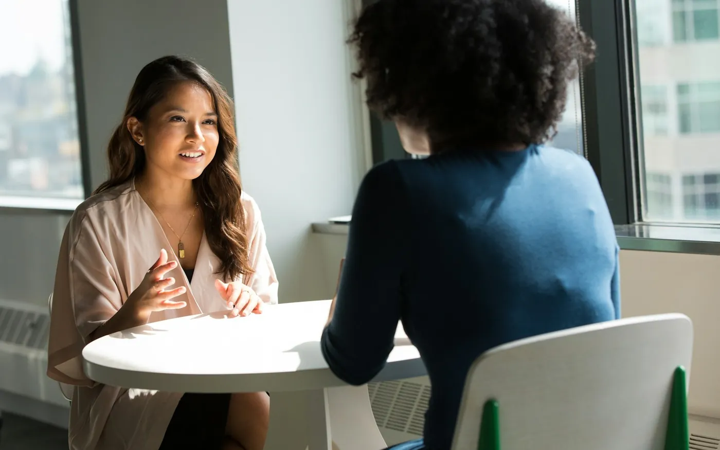 Deux femmes en entretien autour d'une table, dans un bureau