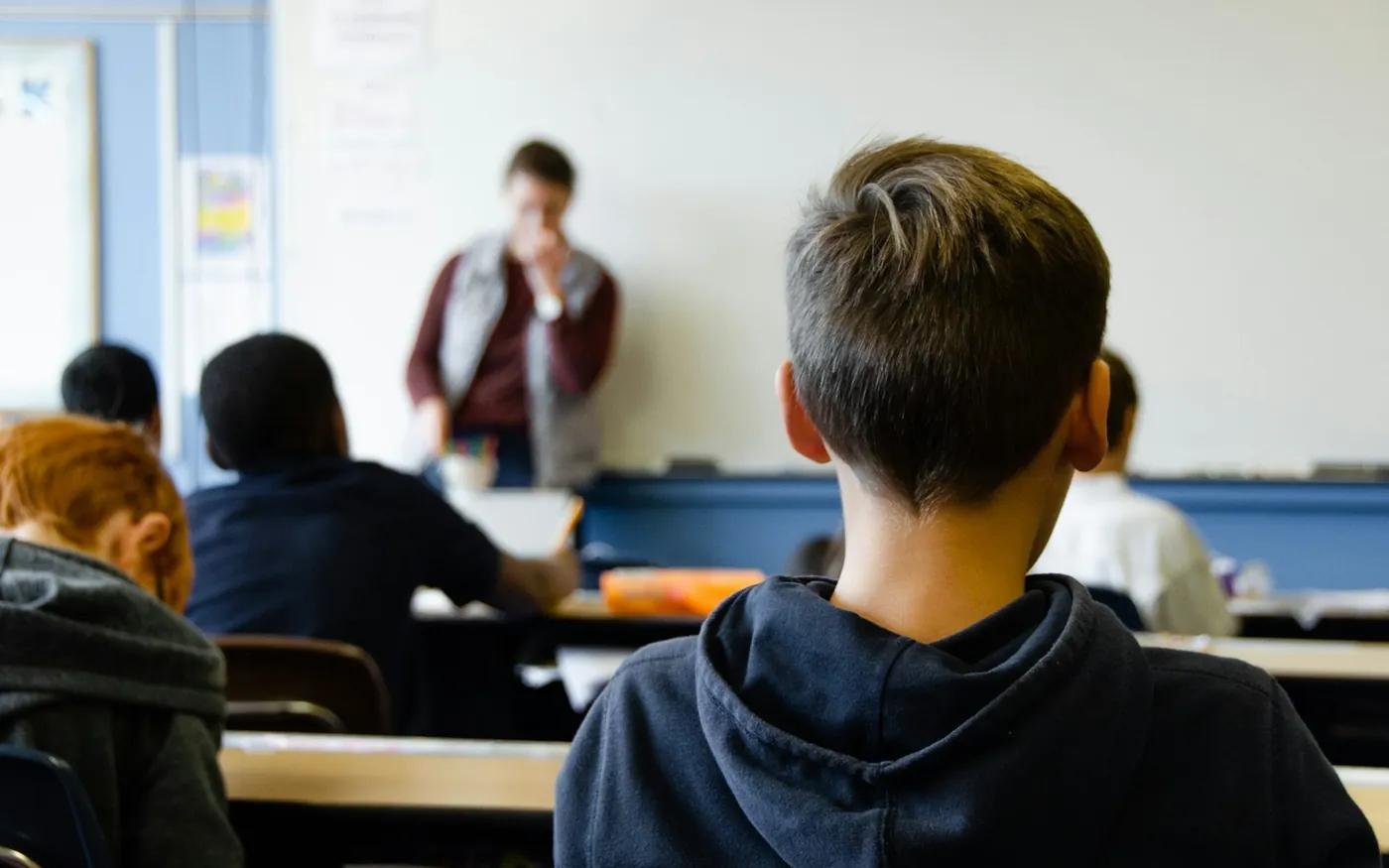 Une salle de classe vue du fond, des élèves face à leur enseignant
